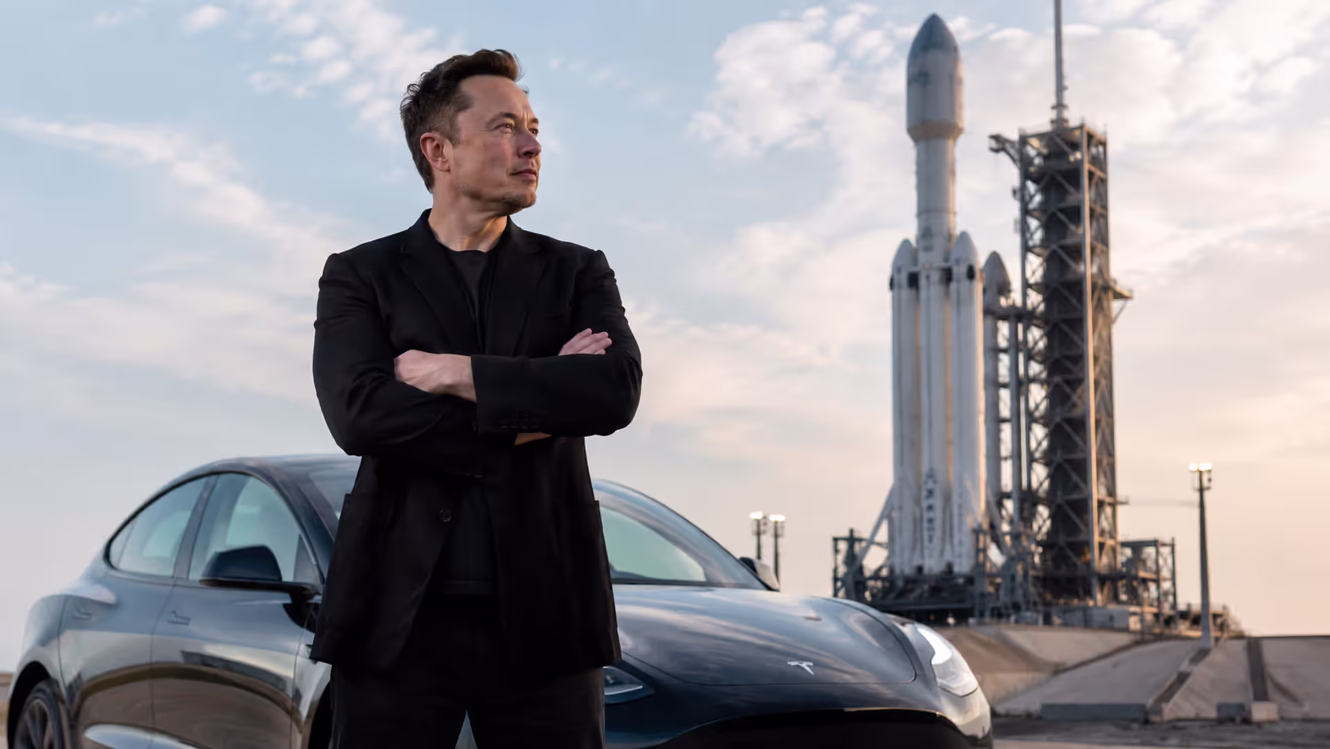 Илон Маск на фоне электромобиля Tesla и ракеты SpaceX